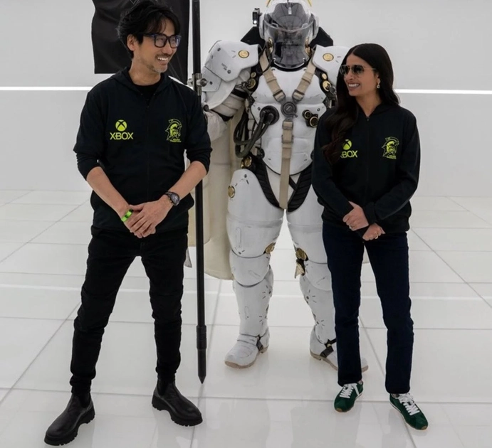 Asha Sharma y Hideo Kojima posan juntos en la sede de Kojima Productions en Tokio, con sudaderas de Xbox y Kojima Productions.