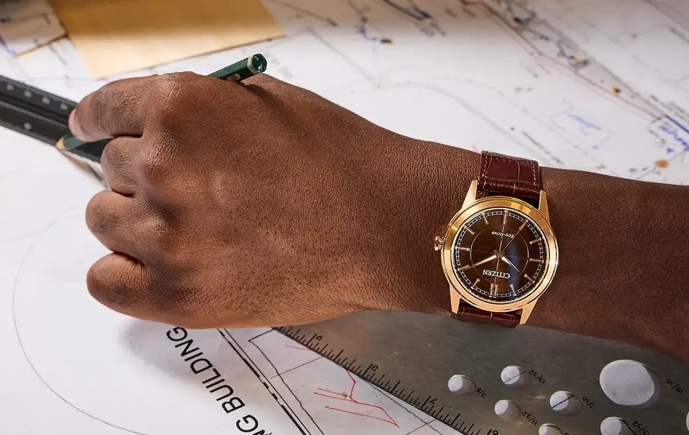 Citizen Rolan AW2113-16X: esfera marrón metálica, caja en oro rosa y correa de piel marrón.