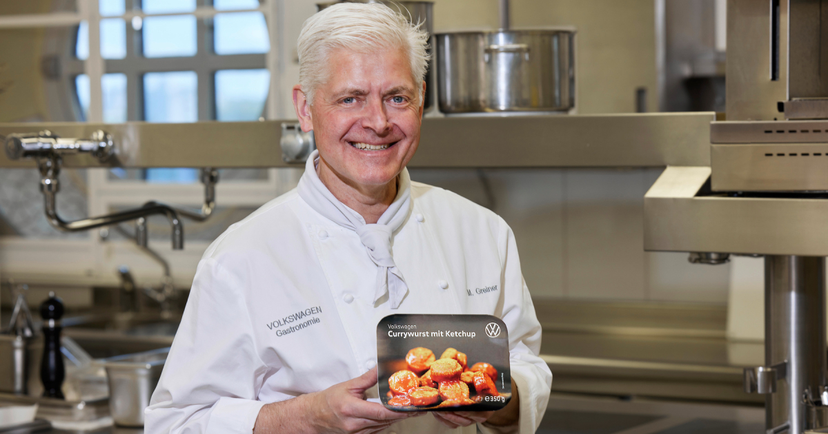 Markus Greiner con un paquete de Currywurst mit Ketchup